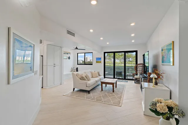 a living room with furniture large windows and a flat screen tv