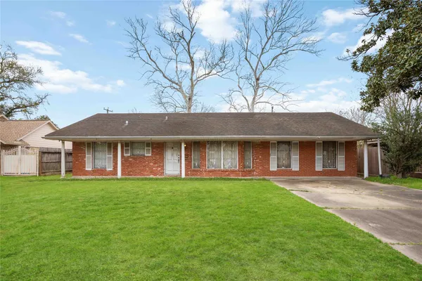 front view of a brick house with a yard
