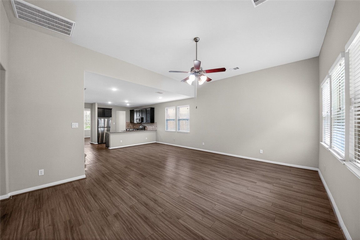 2518 Cold River Drive Humble, TX 77396 - Photo 19 of 35 a view of an empty room with wooden floor kitchen view and a window