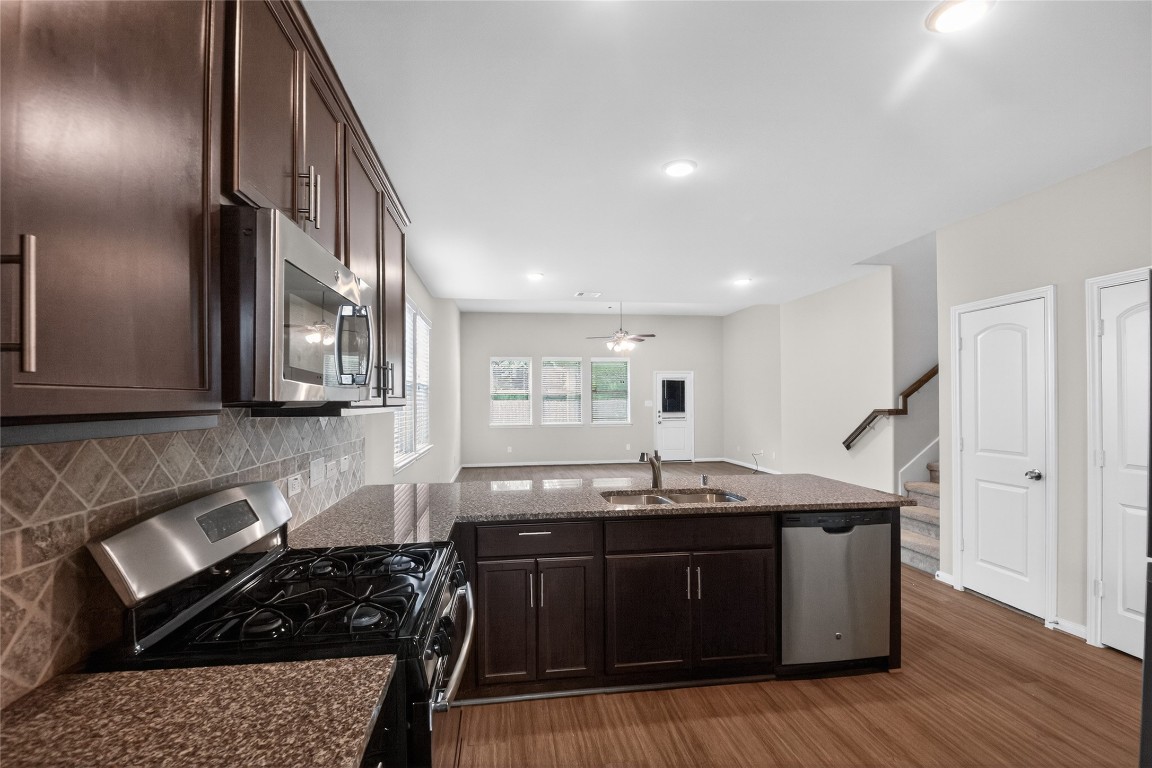 2518 Cold River Drive Humble, TX 77396 - Photo 26 of 35 a kitchen with granite countertop a sink a stove and cabinets