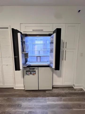 a view of kitchen with stainless steel appliances wooden floor