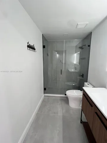 a bathroom with a shower a toilet and sink