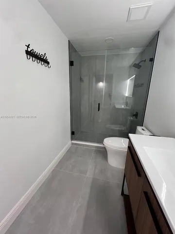 a bathroom with a sink a toilet a mirror and shower