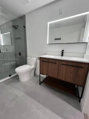 a bathroom with a sink mirror vanity and toilet