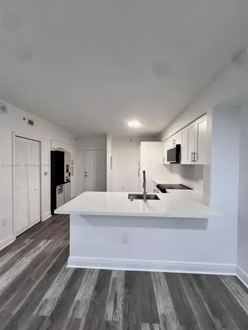 a kitchen with stainless steel appliances a sink a stove and a microwave