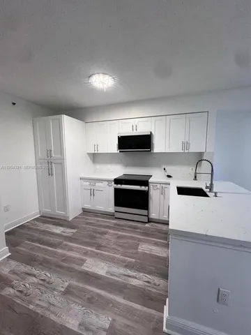 a kitchen with a sink stainless steel appliances and cabinets