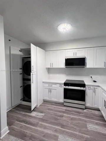 a kitchen with a refrigerator stove and white cabinets
