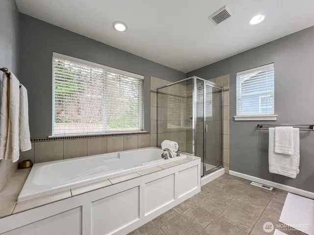 a spacious bathroom with a tub sink and mirror