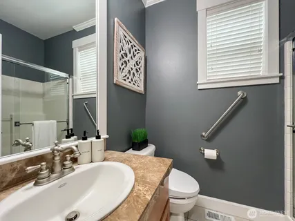 a bathroom with a granite countertop sink a toilet and a mirror