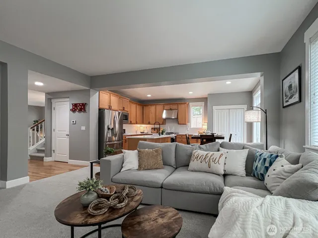 a living room with furniture kitchen and a large window