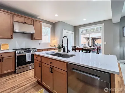 a kitchen with stainless steel appliances granite countertop a sink stove and microwave