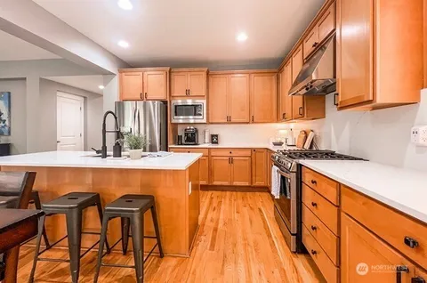 a kitchen with a table chairs sink and cabinets