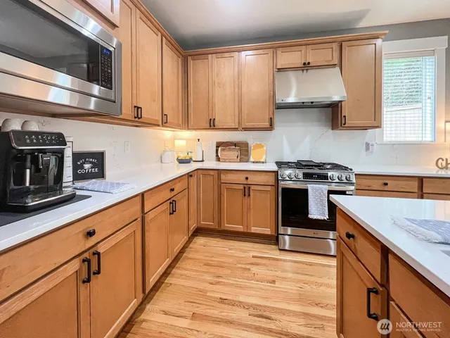 a kitchen with stainless steel appliances granite countertop a sink stove and microwave