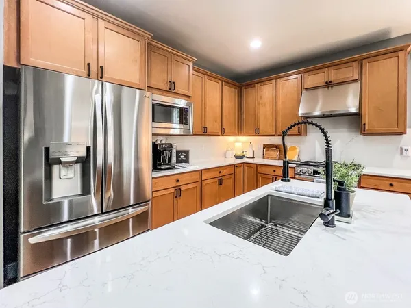 a kitchen with granite countertop a refrigerator and a sink