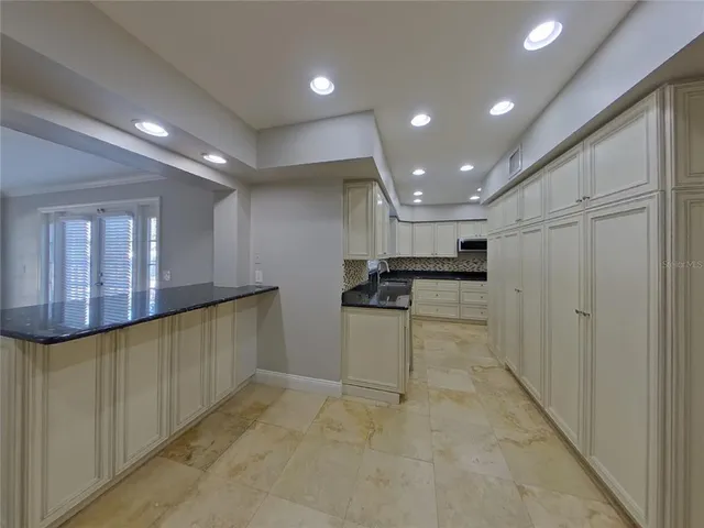 a view of kitchen with stainless steel appliances granite countertop refrigerator and cabinets