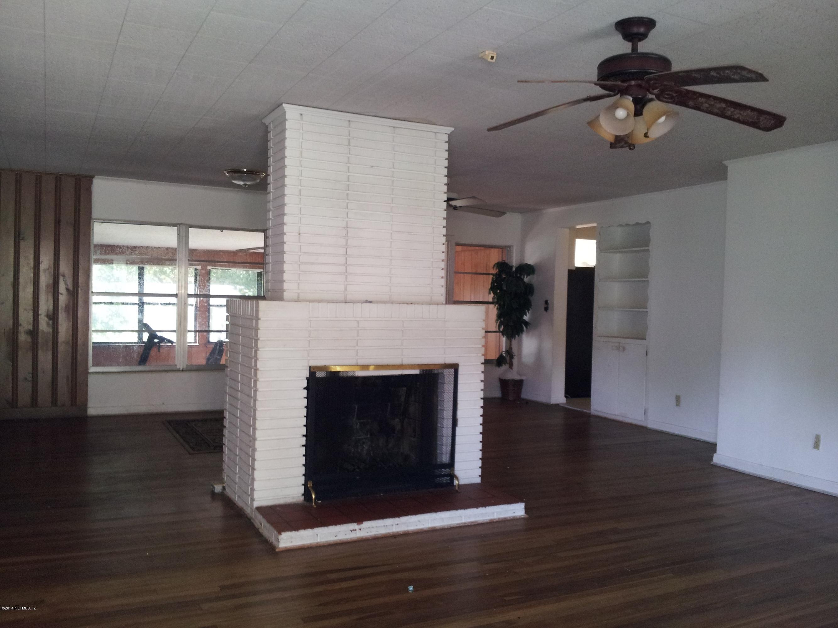6542 Colgate Road Jacksonville, FL 32217 - Photo 6 of 9 a living room with wooden floors and a fireplace