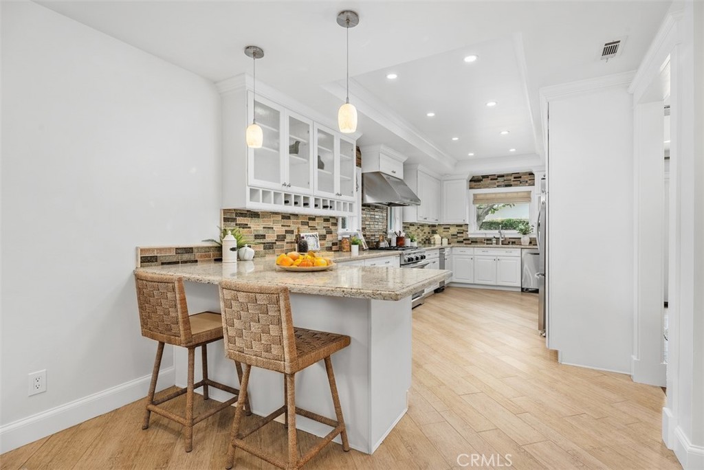 1015 Nottingham Road Newport Beach, CA 92660 - Photo 13 of 34 a kitchen with stainless steel appliances kitchen island granite countertop a sink and cabinets