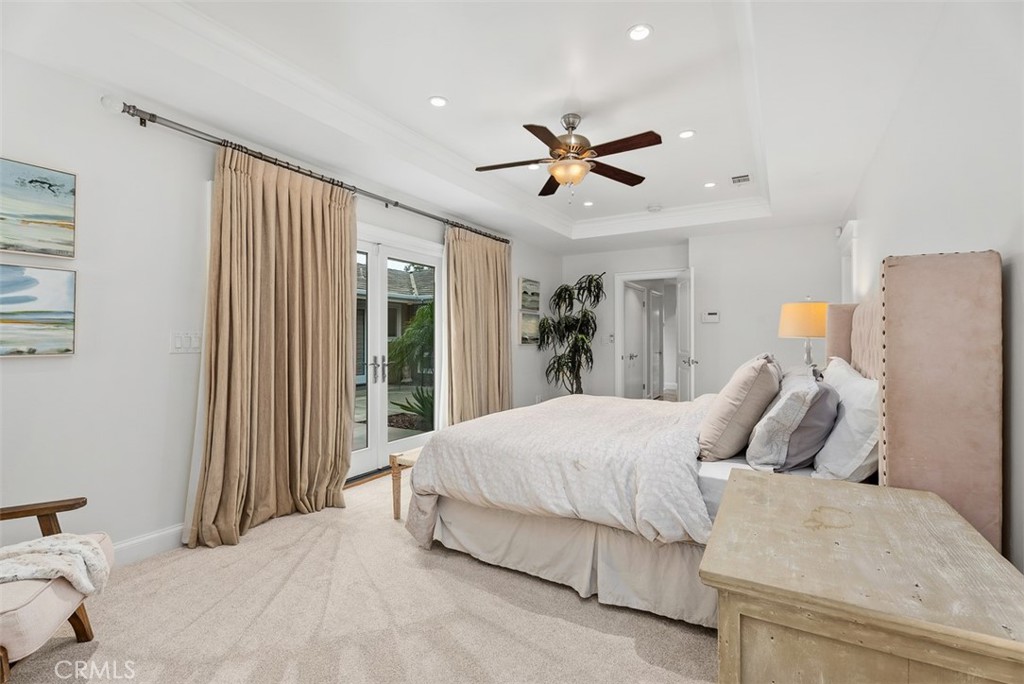 1015 Nottingham Road Newport Beach, CA 92660 - Photo 24 of 34 a bedroom with a large bed and a chandelier