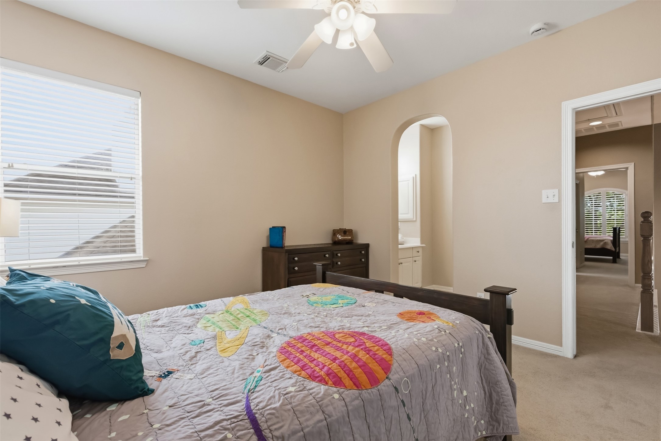 20722 Windrose Bend Drive Spring, TX 77379 - Photo 27 of 50 This cozy bedroom features neutral paint, ceiling fan, and an arched entry to an adjoining Jack & Jill style bathroom.