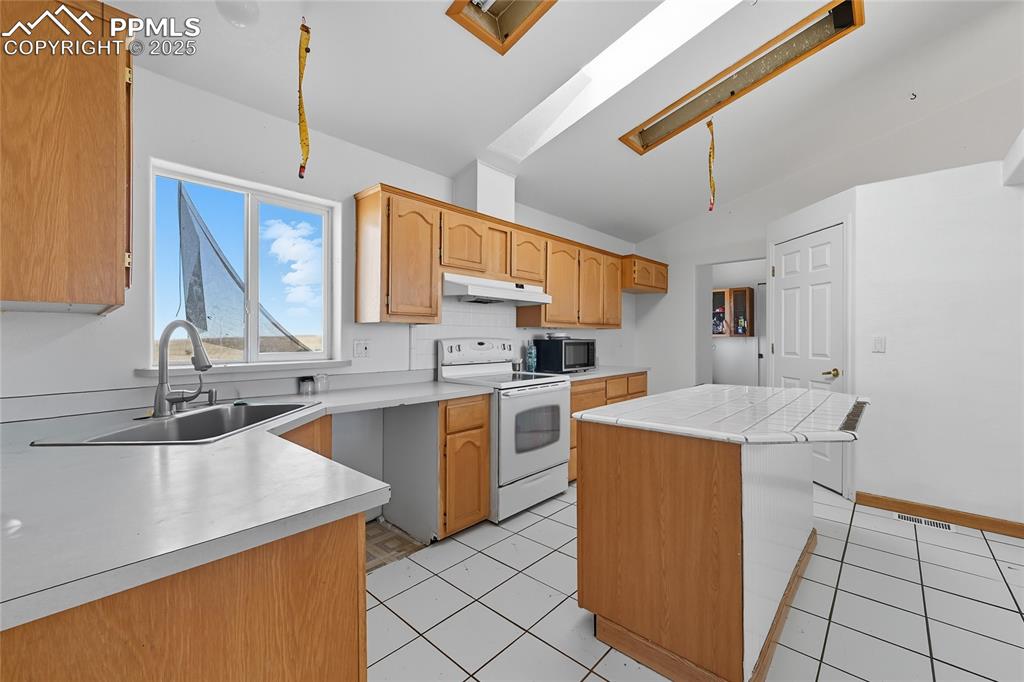 16595 Yoder Road Calhan, CO 80808 - Photo 12 of 28 a kitchen with a sink a stove a refrigerator and cabinets