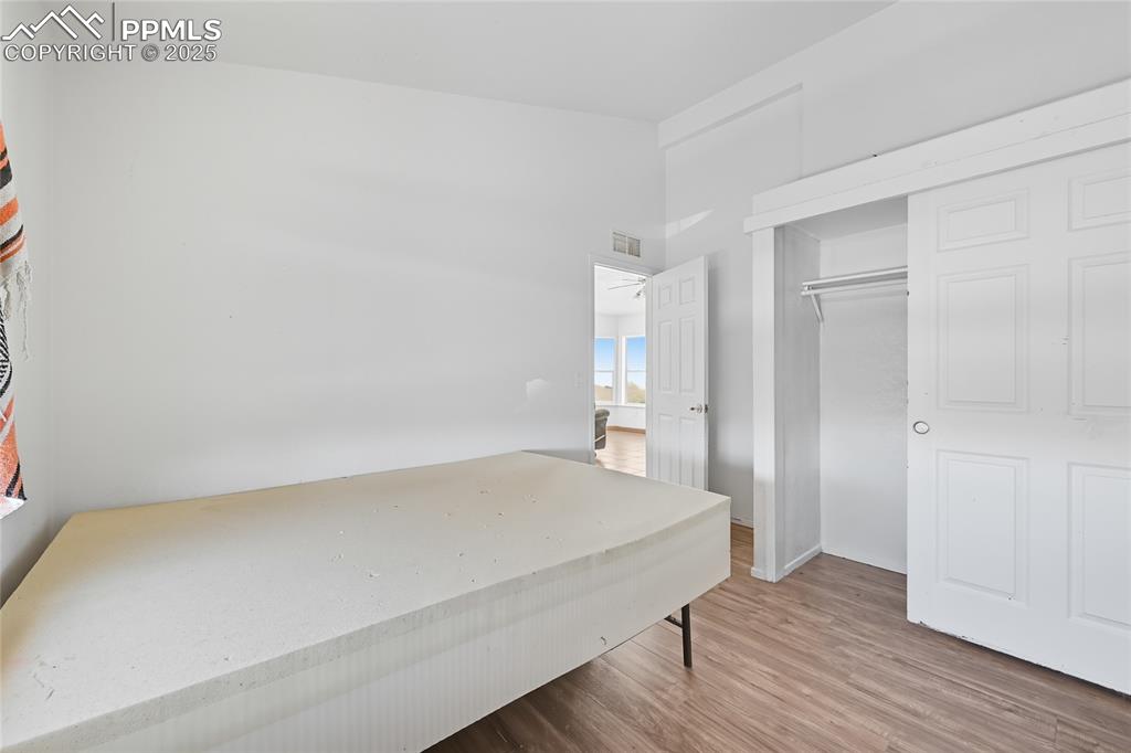 16595 Yoder Road Calhan, CO 80808 - Photo 20 of 28 a bedroom with a bed and wooden floor