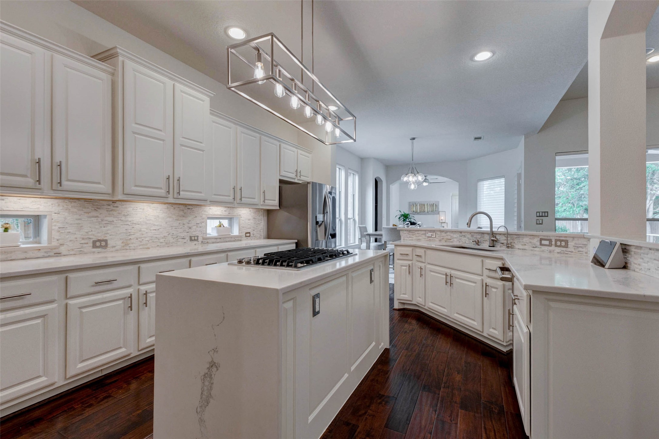27602 Guthrie Ridge Lane Katy, TX 77494 - Photo 16 of 50 Thoughtfully designed with ample storage and a functional layout for everyday living, the kitchen is enhanced by under-cabinet lighting that elegantly showcases the marble backsplash.
