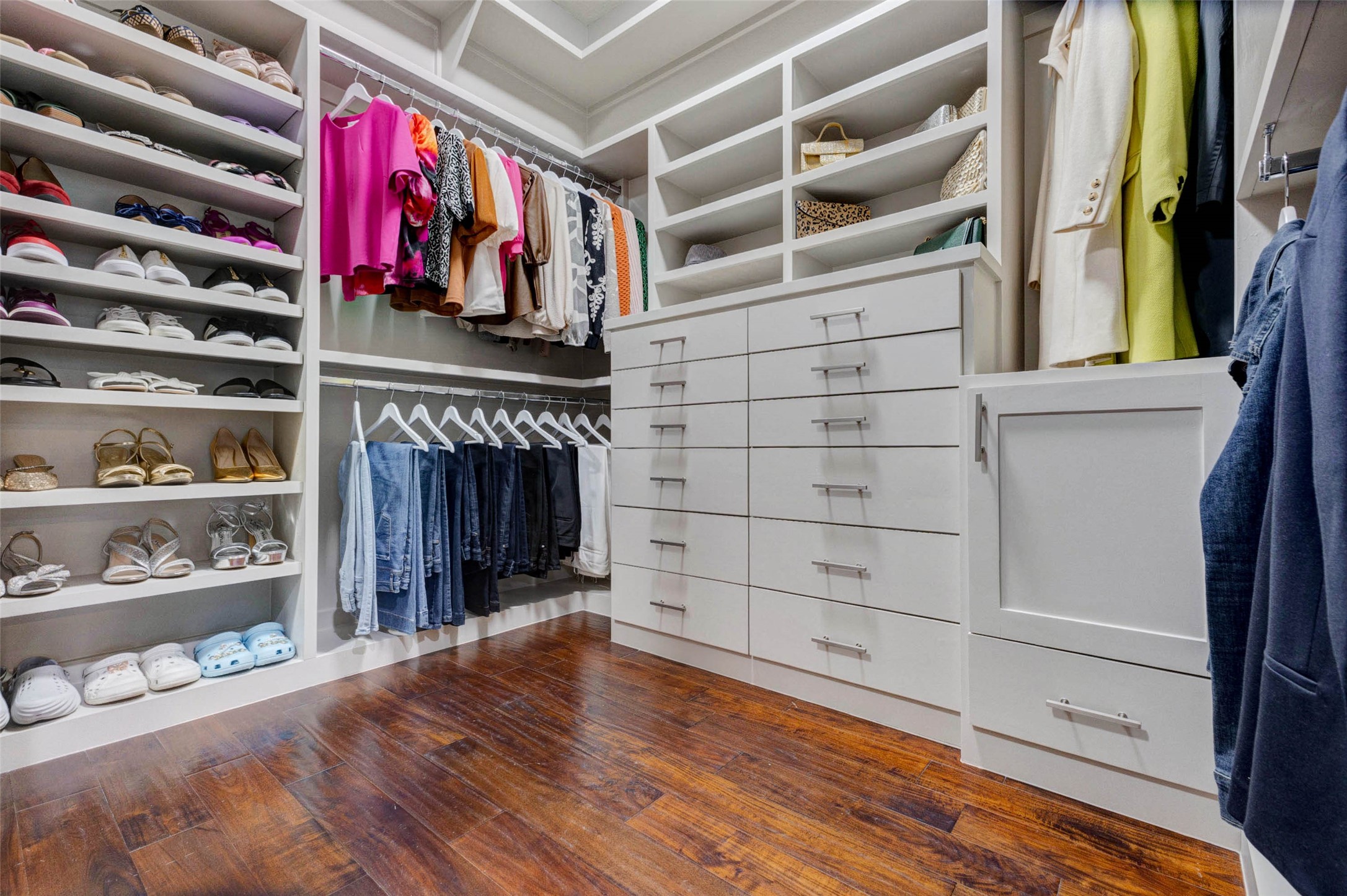 27602 Guthrie Ridge Lane Katy, TX 77494 - Photo 24 of 50 Custom walk-in closet with extensive built-ins, shelving, and drawer storage. A pull-out laundry hamper with dual baskets is discreetly concealed behind the cabinet door on the right.