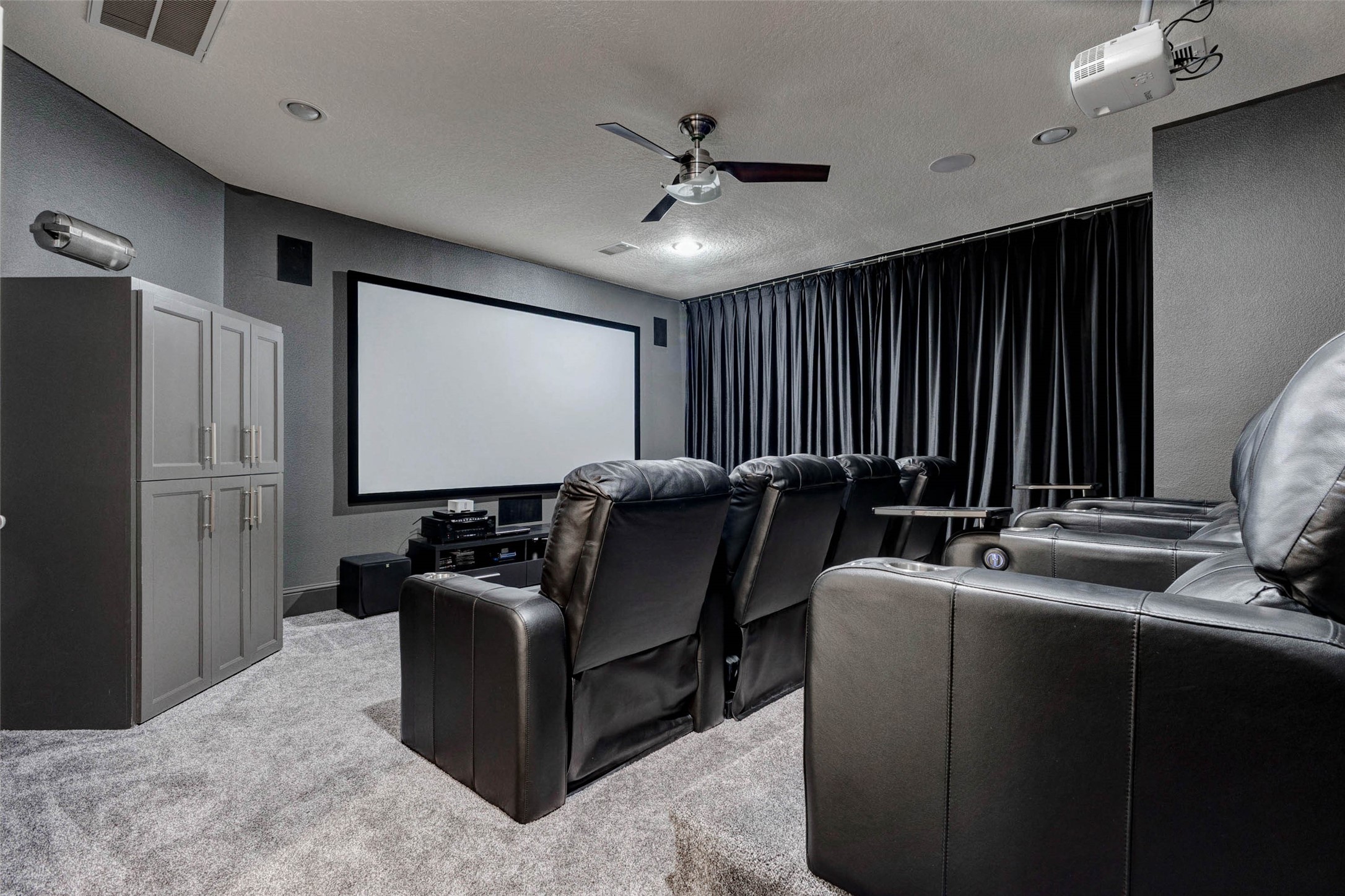 27602 Guthrie Ridge Lane Katy, TX 77494 - Photo 29 of 50 The upstairs media room is equipped with a 4K UHD 3D projector and 120” screen, both included. The theater-style layout features tiered flooring and blackout curtains for an immersive experience. The built-in cabinet discreetly houses a refreshment station with a microwave and beverage cooler adding convenience for extended entertainment. Seating and surround system is not included.