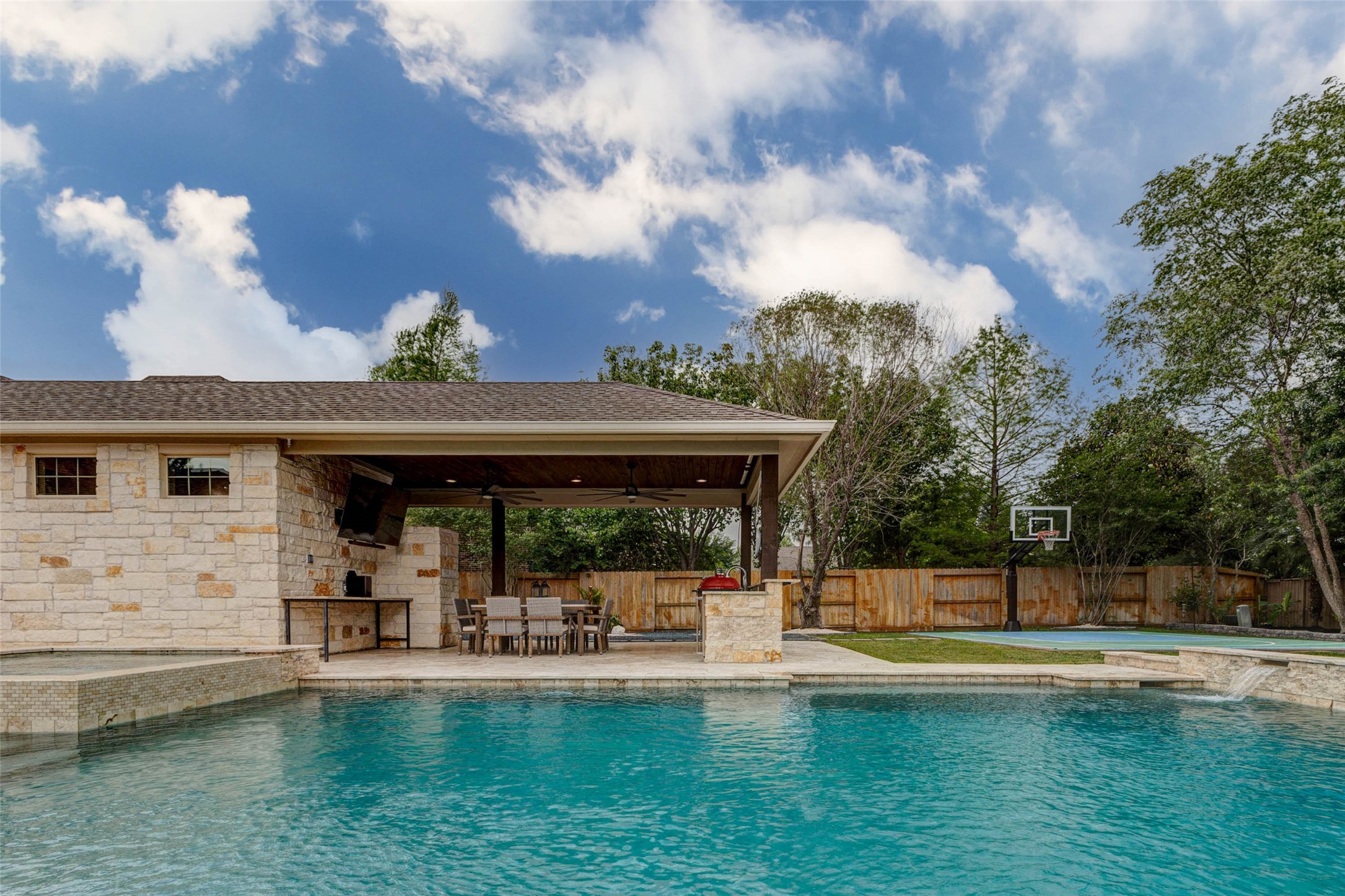 27602 Guthrie Ridge Lane Katy, TX 77494 - Photo 41 of 50 A resort-inspired backyard showcases a sparkling pool and spa, a covered outdoor kitchen, spacious dining area, extended counter height sitting area and a private sport court, creating a complete outdoor living experience.