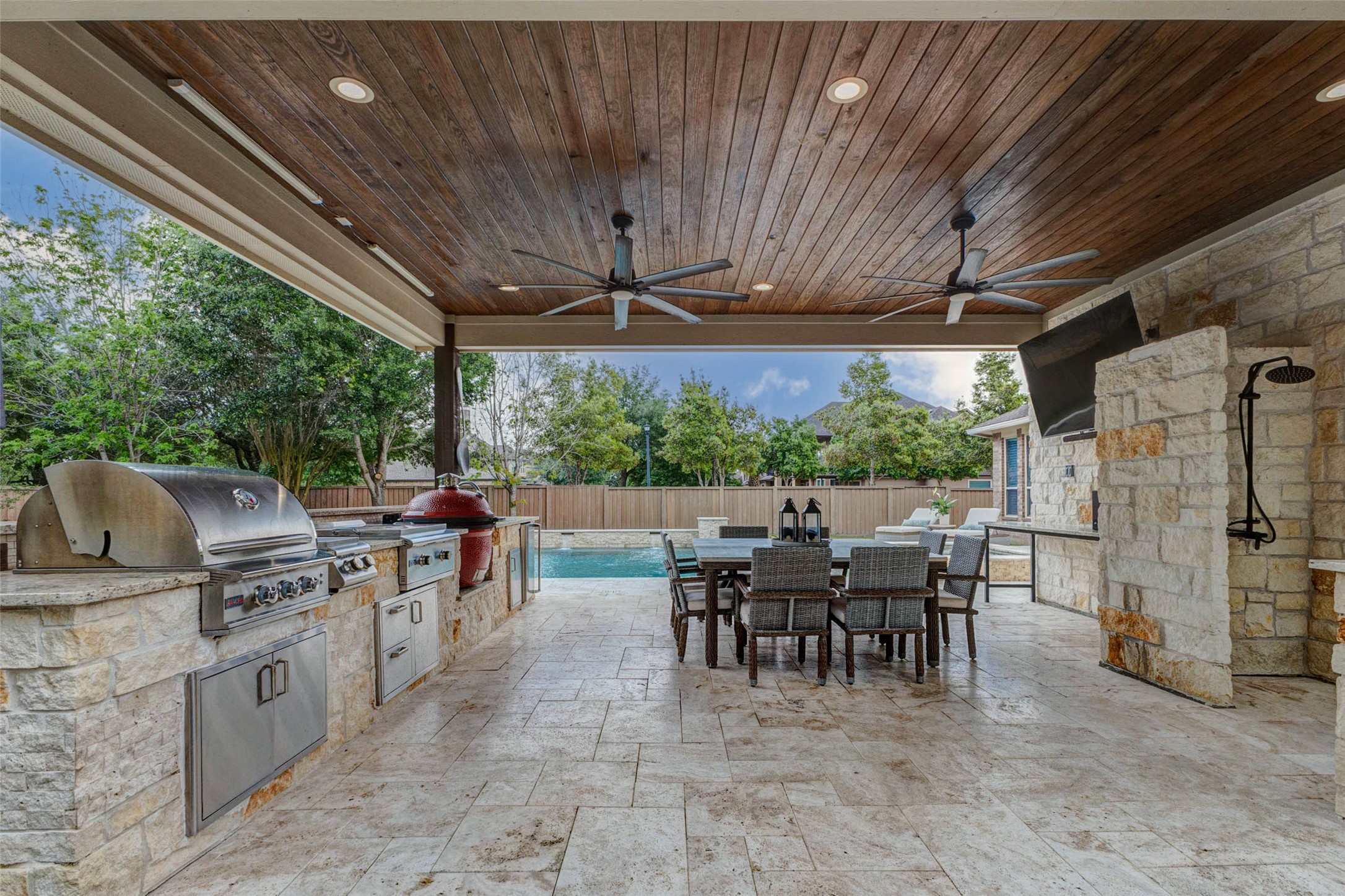 27602 Guthrie Ridge Lane Katy, TX 77494 - Photo 42 of 50 The covered patio creates an ideal entertaining environment with a fully equipped outdoor kitchen, ample dining space, and seamless pool views, creating an inviting setting for gatherings, with a 75” TCL 4K QLED TV with Polk soundbar and subwoofer (included) for added entertainment.