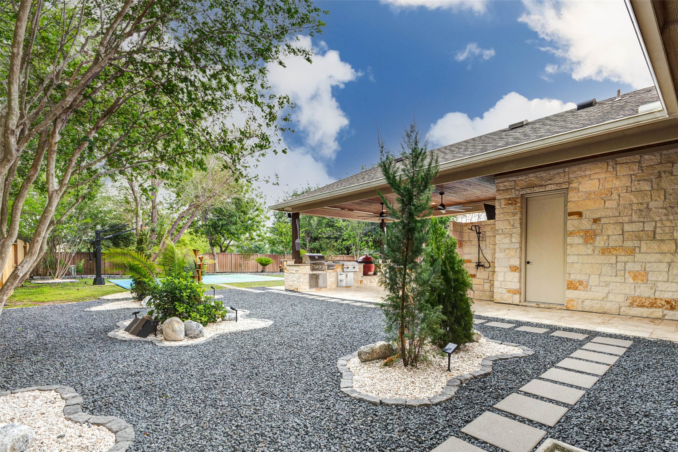 27602 Guthrie Ridge Lane Katy, TX 77494 - Photo 44 of 50 Designed for relaxation, the stone garden incorporates large natural stones and a gold solar-powered fountain that adds a calming ambiance. The patio area also features a discreet outdoor shower and a dedicated pool restroom conveniently located behind the door shown.