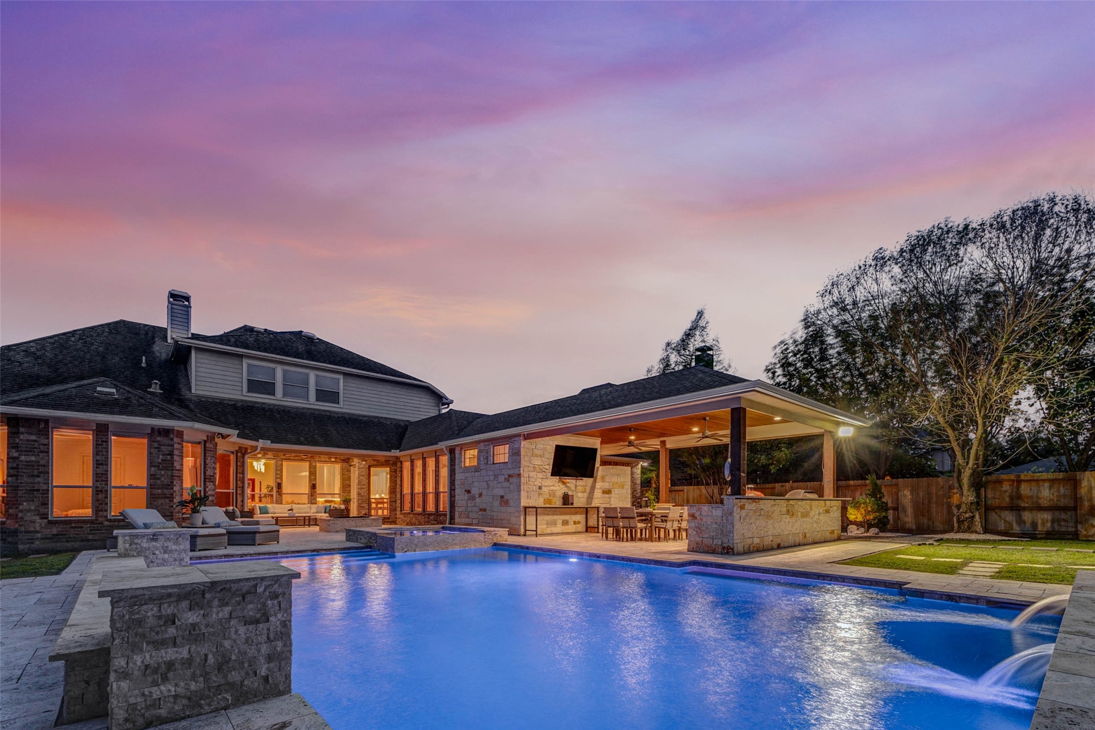 27602 Guthrie Ridge Lane Katy, TX 77494 - Photo 46 of 50 Evening ambiance highlights the illuminated water features, complemented by a fire pit positioned behind the spa for added warmth and ambiance.