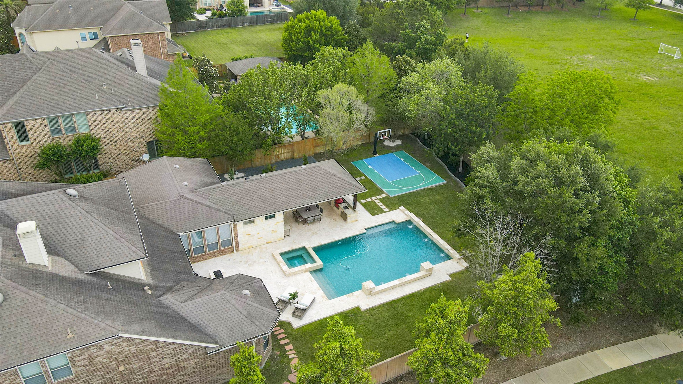 27602 Guthrie Ridge Lane Katy, TX 77494 - Photo 48 of 50 Aerial view showcases the full backyard layout framed by a mature tree-lined perimeter and open green space beyond for enhanced privacy.