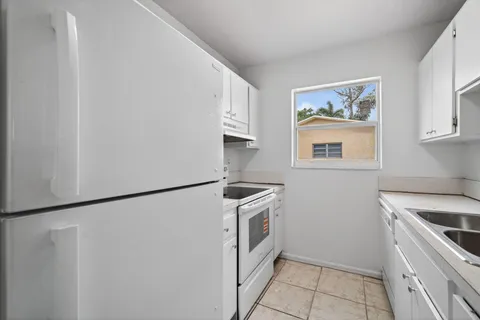a kitchen with stainless steel appliances granite countertop white refrigerator and a stove top oven