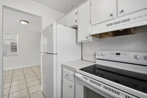 a kitchen with white cabinets and white appliances