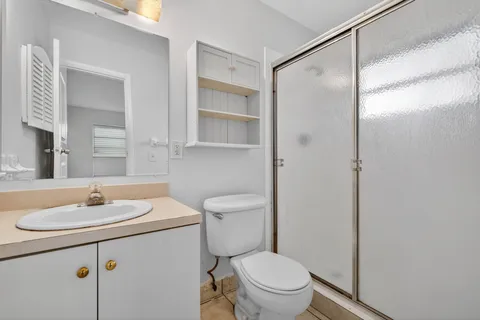 a bathroom with a sink toilet vanity and shower