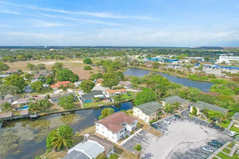 an aerial view of ocean and residential houses with outdoor space