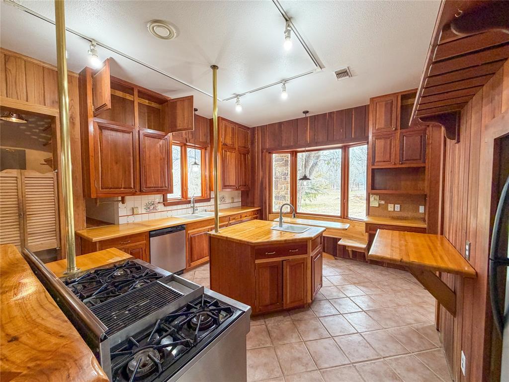 322 Wild Wood Drive Decatur, TX 76234 - Photo 5 of 39 a large kitchen with stainless steel appliances a stove a sink and a refrigerator