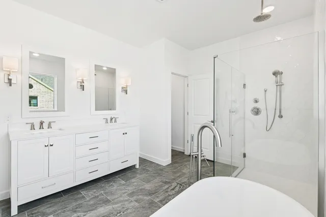a bathroom with a white sink a vanity and shower