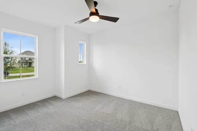 an empty room with a ceiling fan and a window