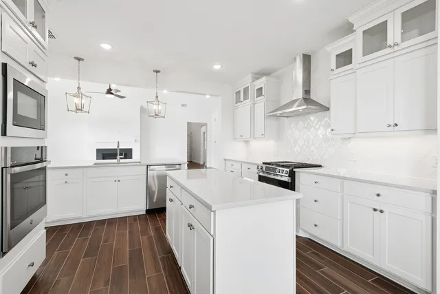a kitchen with white cabinets stainless steel appliances and sink