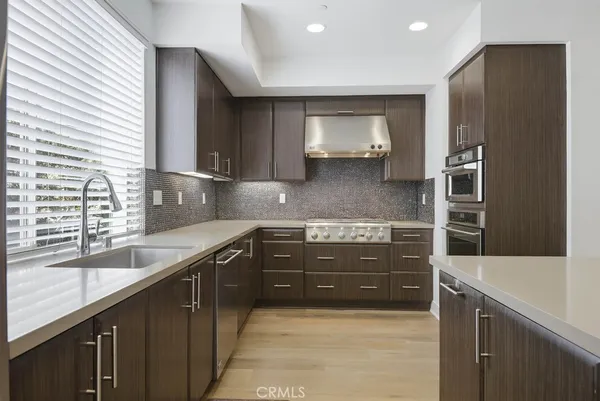 a kitchen with stainless steel appliances a microwave a stove and refrigerator