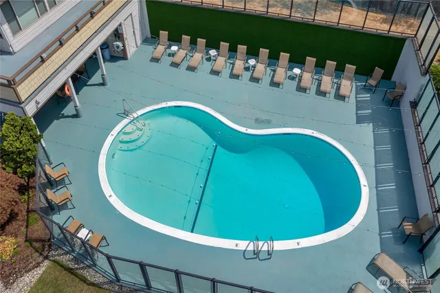an aerial view of a house with swimming pool and outdoor seating