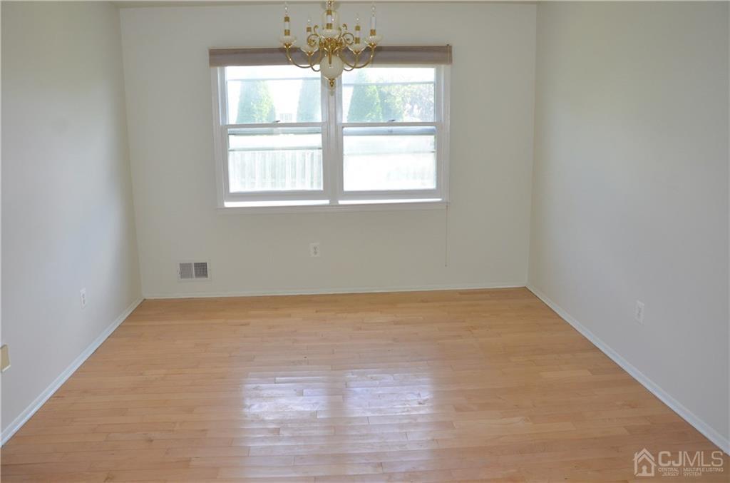 27 Sinclair Road Edison, NJ 08820 - Photo 3 of 15 an empty room with wooden floor and windows