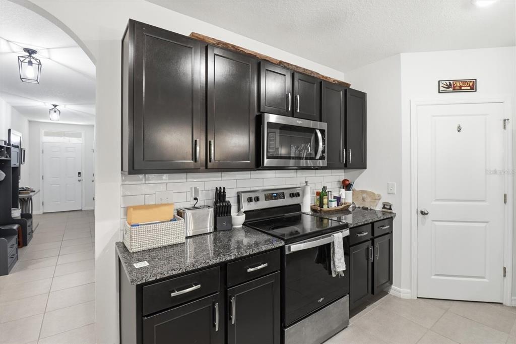 660 Hickory Course Loop Ocala, FL 34472 - Photo 10 of 45 a kitchen with stainless steel appliances granite countertop a sink stove and microwave
