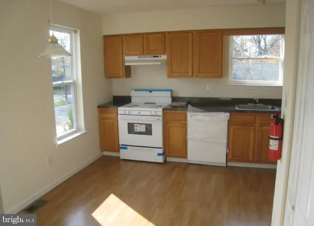 a kitchen with a stove a sink and a window
