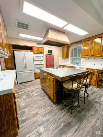 a kitchen with stainless steel appliances granite countertop a sink a stove and a refrigerator