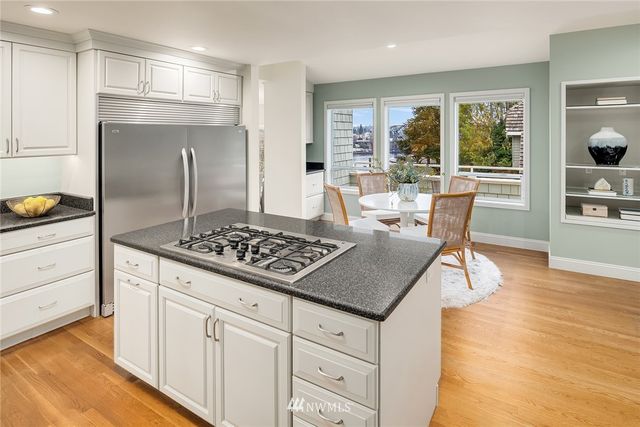 a kitchen with kitchen island a counter top space a sink stainless steel appliances and cabinets