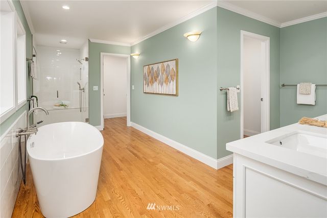 a spacious bathroom with a granite countertop sink a mirror and a bathtub