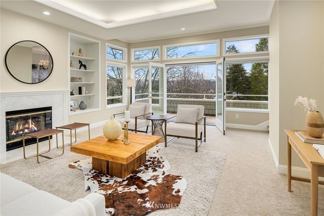 a living room with furniture a rug a large window and a fireplace